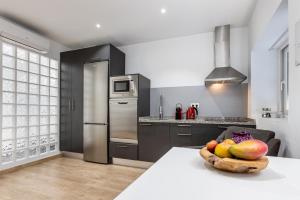 a kitchen with a bowl of fruit on a table at Pinzon Studios & Penthouse in Alicante