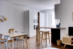 - une cuisine avec une table en bois et des chaises dans l'établissement Apartamentos do Rio, à Tavira