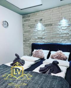 a bedroom with two beds and a wall at LV Spa & Apartment in Ledinci