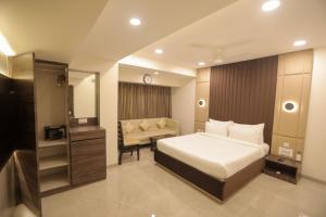Un dormitorio con una cama y una silla dentro. en Hotel Naaz Executive, en Bombay