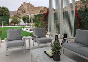 a patio with two chairs and a table with a view at Quiet House villa in Hatta