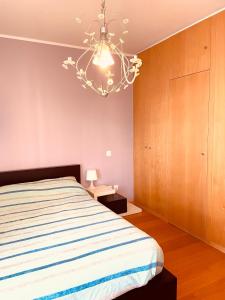 1 dormitorio con cama y lámpara de araña en Apartamento foz village, en Buarcos