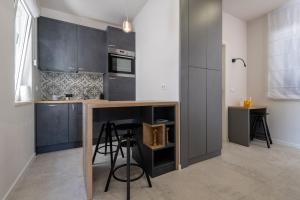 a kitchen with black cabinets and a counter with stools at Luxury Seaview Apartment - Sole in Slano