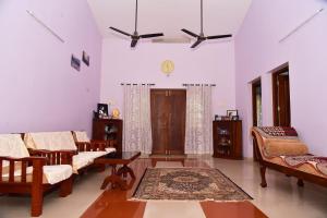 een woonkamer met stoelen en een tapijt bij Bella Apartments in Tellicherry