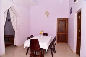a dining room with a white table and chairs at Bella Apartments in Tellicherry