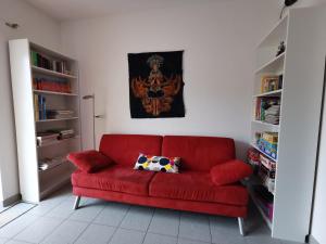 a red couch in a room with bookshelves at Apartment close to Lake Ferienwohnung Seenah in Sipplingen