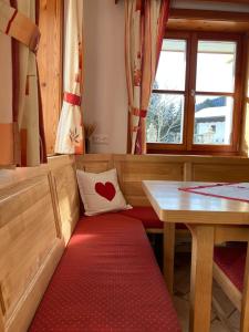 a seat in a train with a heart pillow and a table at Ferienwohnungen Hannesbichler in Patergassen