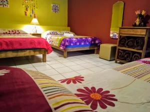 a room with two beds with flowers on them at Casa Cantares in Guanajuato