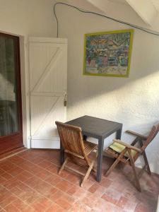 uma mesa e duas cadeiras sentadas ao lado de uma porta em Appartement entier: chambre, cuisine + terrasse au calme sur jardin. em Marigot