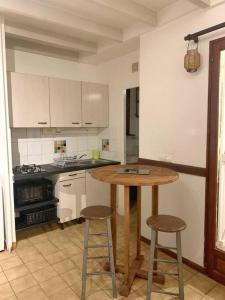 uma cozinha com uma mesa de madeira e 2 bancos de bar em Appartement entier: chambre, cuisine + terrasse au calme sur jardin. em Marigot