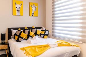 a bedroom with a bed with yellow and black pillows at Charming Studio Retreat I1Bed1Bath Haven in London in London