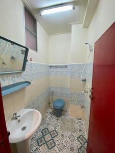 a bathroom with a sink and a blue toilet at Ratanawong Place 506 in Bangkok