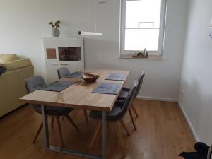 a dining room with a wooden table and chairs at Ferienwohnung MeerBlick OG in Altefähr