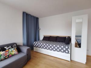 a bedroom with a bed with a mirror and a couch at Apartment close to Lake Ferienwohnung Seenah in Sipplingen