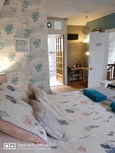 Un dormitorio con una cama grande con almohadas. en Maison Papillons, en Plomodiern