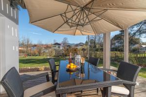 a patio with a table and chairs and an umbrella at Helle Wohnung mit Bergblick & eigener Terrasse in Bad Tölz