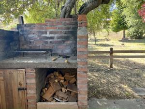 a brick oven with a pile of fire wood at Fly Fishing Cabin, River Coast. in Los Helechos