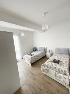 um quarto branco com 2 camas e um sofá em Sicilia Bedda casavacanze em Pozzallo