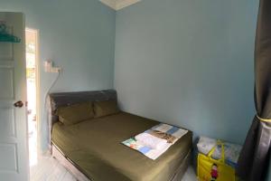 a small bed in a corner of a room at Amy Homestay-Suasana kampung yang nyaman in Pasir Mas