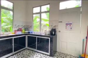 a kitchen with a counter and a window and a door at Amy Homestay-Suasana kampung yang nyaman in Pasir Mas