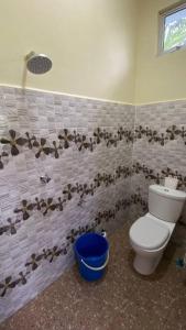 a bathroom with a toilet and flowers on the wall at Amy Homestay-Suasana kampung yang nyaman in Pasir Mas