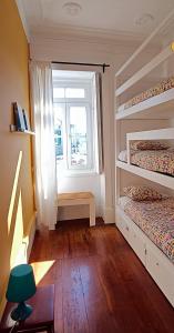 1 dormitorio con 2 literas y ventana en Aveiro Rossio Hostel, en Aveiro