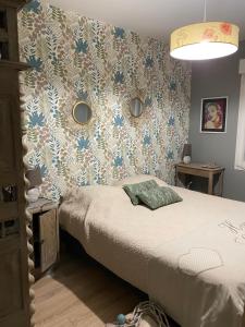 a bedroom with a bed and a floral wallpaper at La clé des champs in Acheux-en-Vimeu