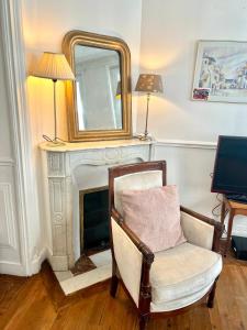 espejo y silla en una habitación con chimenea en BASSANO, en París