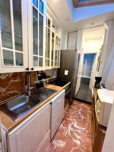 uma cozinha com um lavatório e um fogão forno superior em BASSANO em Paris