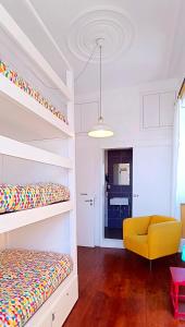 a bedroom with bunk beds and a yellow chair at Aveiro Rossio Hostel in Aveiro