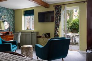 a living room with green walls and blue chairs at St Johns House Lichfield in Lichfield