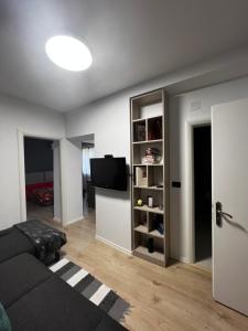 AmIon Apartment in Center of Tirana في تيرانا: غرفة معيشة مع أريكة وتلفزيون بشاشة مسطحة