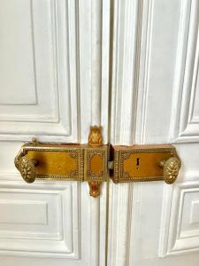 a wooden door with a gold handle on a white door at BASSANO in Paris