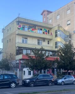 un edificio con coches estacionados frente a él en Hostel Central Shkoder, en Shkodër