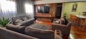 uma sala de estar com dois sofás e uma televisão em Casa temporada Campos do Jordão em Campos do Jordão