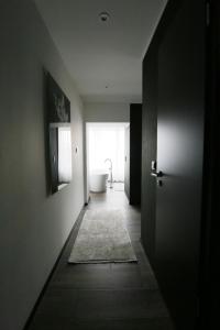 a hallway with a bathroom with a toilet and a tub at Sellmann´s Boutique Hotel in Dortmund