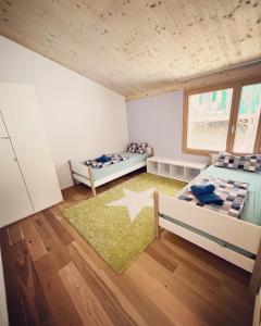 a bedroom with two beds and a star rug at 3 bedroom condo in front of Obersaxen ski resort in Obersaxen