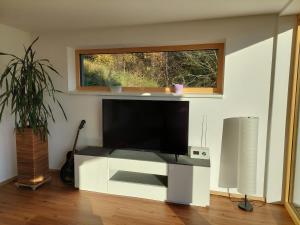 a flat screen tv in a living room with a window at Casa Farnach in Bildstein