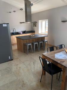 a kitchen with a table and chairs and a counter at Ferme La Clavière, Gîte Lou Mas in Mane