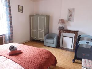 ein Schlafzimmer mit einem Bett, einem Stuhl und einem Spiegel in der Unterkunft LA GOELETTE et son jardin clos sans parking privé in Étretat