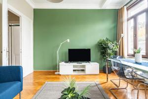 a living room with a green wall and a tv at Chic Taksim Flat 1 min to Istiklal Ave in Istanbul