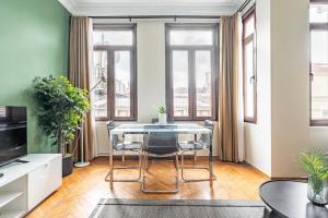 a dining room with a table and chairs and windows at Chic Taksim Flat 1 min to Istiklal Ave in Istanbul