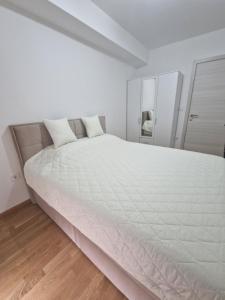 - un grand lit blanc dans une chambre blanche dans l'établissement The Apartment, à Skopje