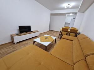 - un salon avec un canapé et une télévision dans l'établissement The Apartment, à Skopje