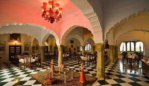 a restaurant with a checkered floor and a chandelier at Fort Barli - A 16th Century Castle in Barli