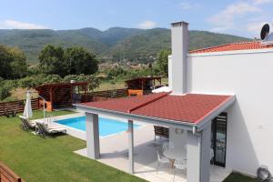 a villa with a swimming pool and mountains in the background at OLYMPUS Paradise 3 in Skotina