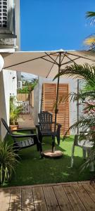 une terrasse avec une table et un parasol dans l'établissement KAZ A NINE, à Saint-Pierre