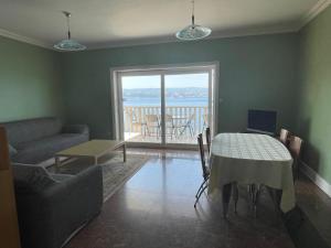 ein Wohnzimmer mit einem Tisch und Meerblick in der Unterkunft Apartments Lozina on the Beach in Omiš