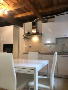 a kitchen with a white table and white chairs at Casa Gioia Centro Storico in Bologna