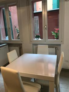 a table and chairs in a room with windows at Casa Gioia Centro Storico in Bologna